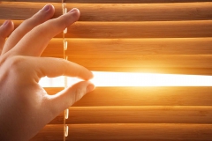 Looking through window blinds, sun light coming inside. Conceptual